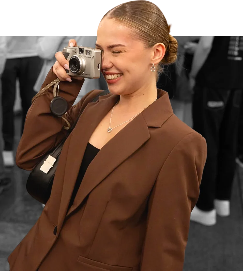 Kamilė taking a photo with a film camera